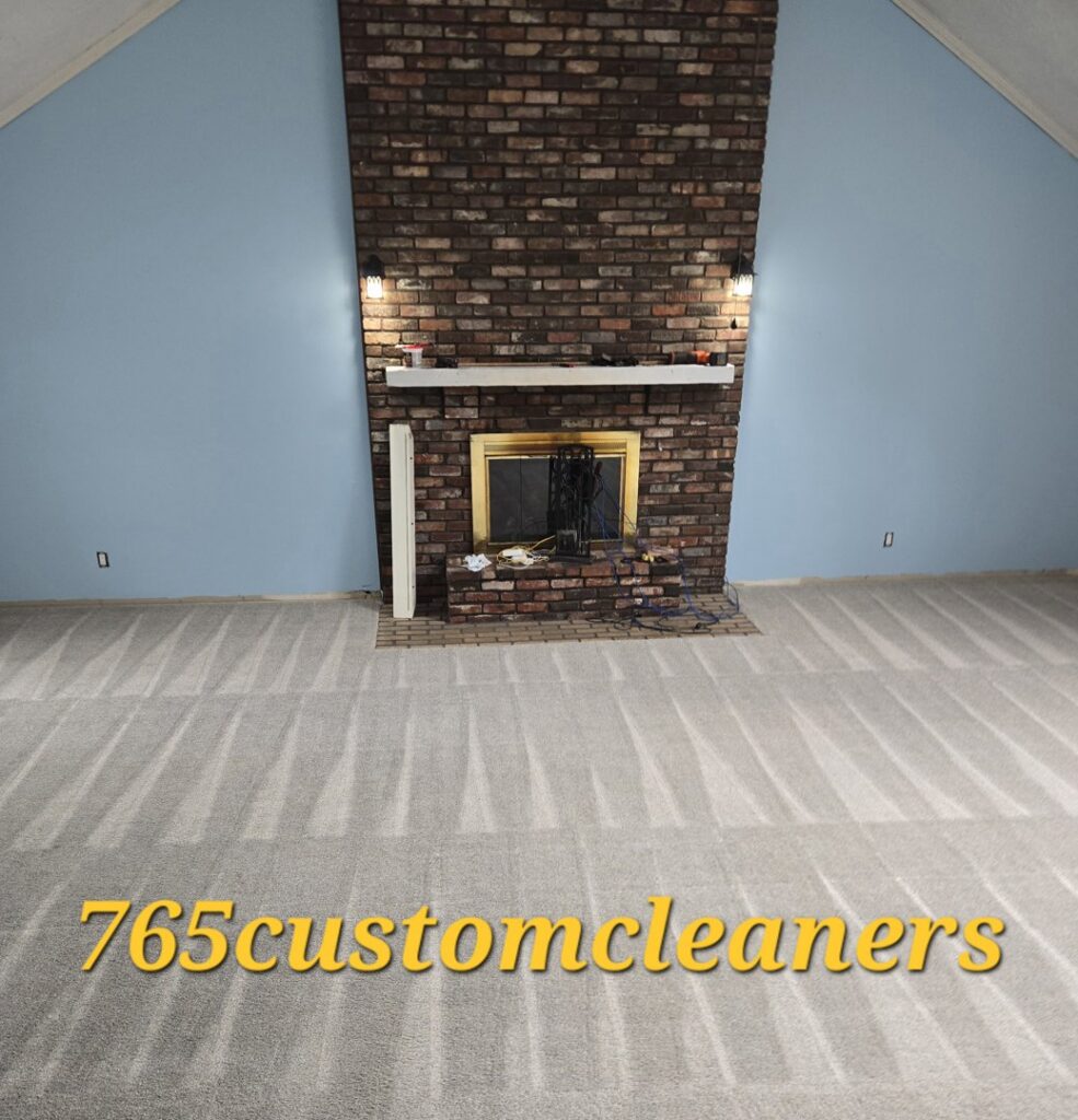 A living room with a brick fireplace and freshly cleaned carpet showing distinct vacuum lines by 765 Custom Cleaners in Lafayette, IN.