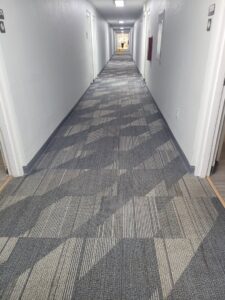 A long hallway with clean, patterned carpet tiles, showcasing the results of Leo's Carpet Cleaning in Omaha, NE