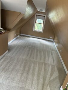 A clean, carpeted attic room showing distinct cleaning lines after professional service by Carpet Cleaners Plus in Chicago, IL.