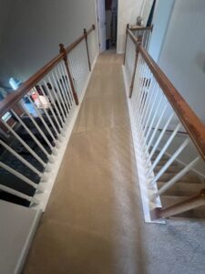A freshly cleaned carpeted hallway and stairs by Drew's Cleaning and Restoration in Jamestown, NC.