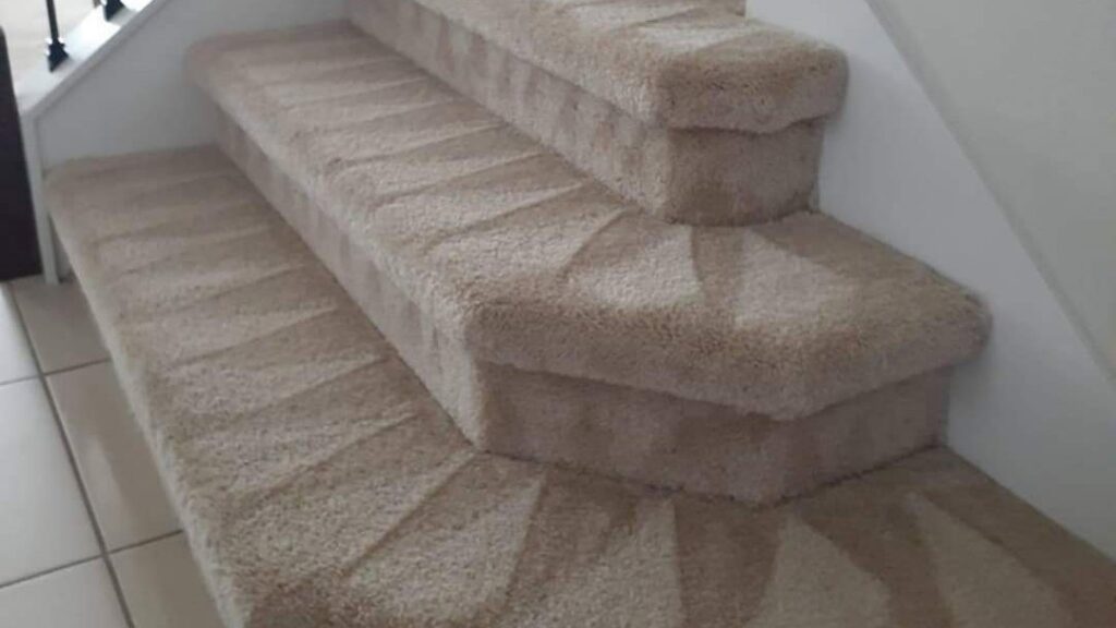 A beautifully cleaned carpeted staircase with clear vacuum lines by Jam Carpet Cleaning Services LLC in Newport News, VA.