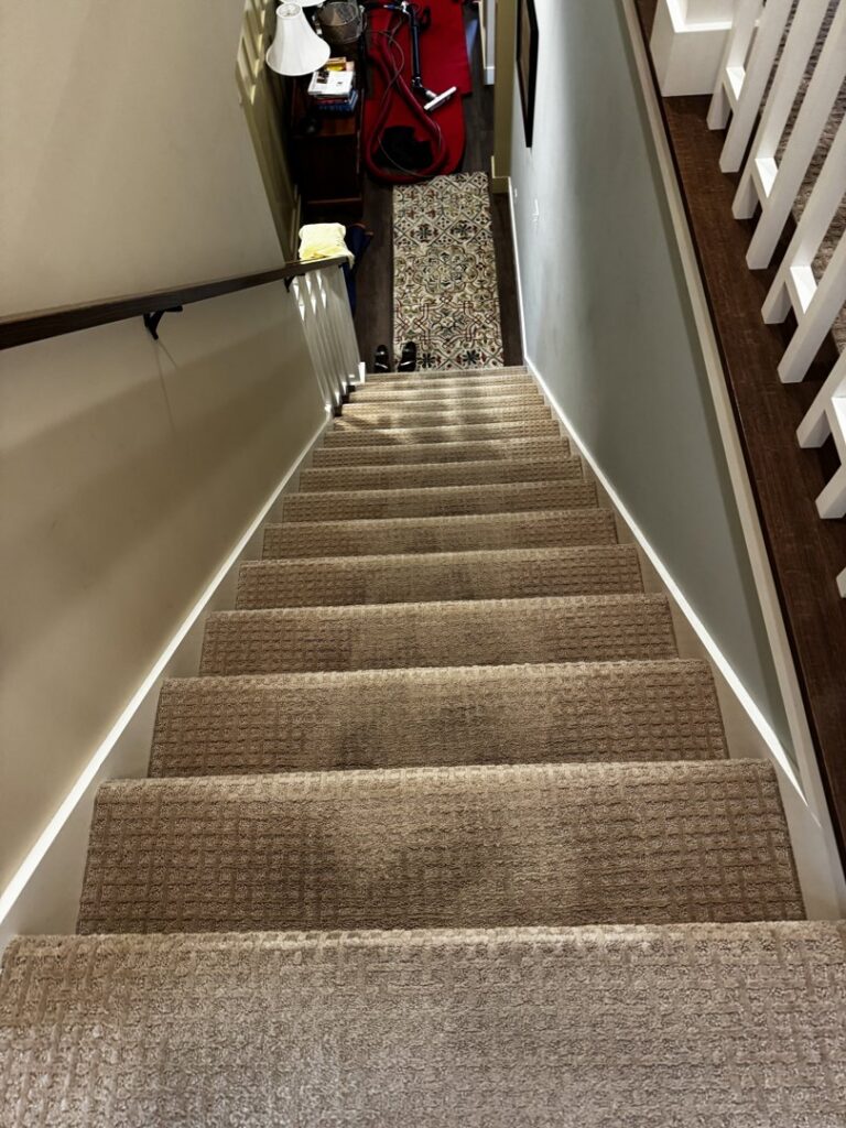 A clean, well-maintained carpeted staircase in a home, serviced by KODA Carpet Cleaning in Holland, MI.