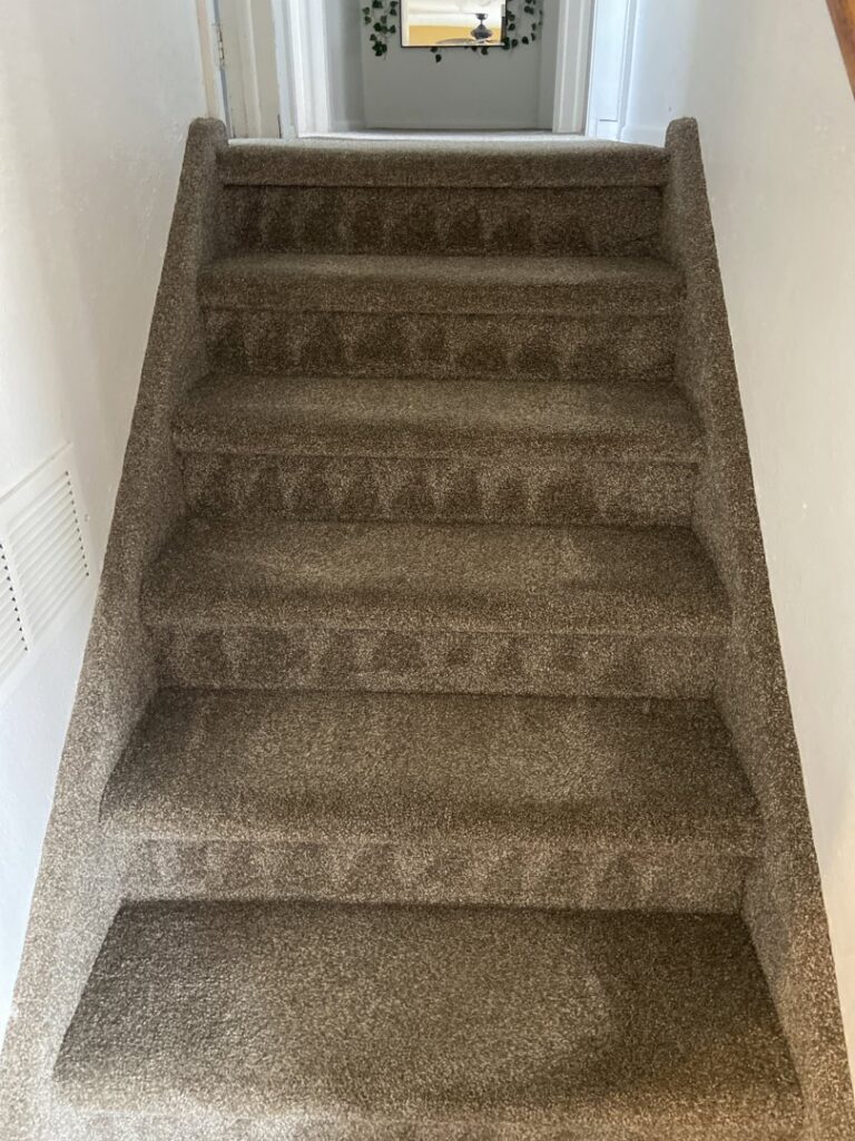 A clean, plush carpeted staircase, showcasing quality work by Tailor Maid Carpet Cleaning in Colorado Springs, CO.