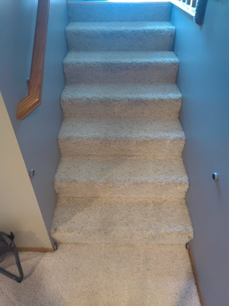 A set of freshly cleaned, light-colored carpeted stairs, showcasing the results from Norris Carpet Care in Watertown, SD.
