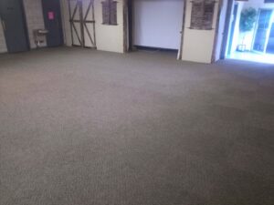 A large room with a clean, dark gray commercial carpet, expertly installed or cleaned by Real Green Cleaning in Indianapolis, IN.