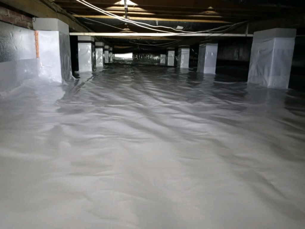 A clean crawl space with a newly installed vapor barrier by Global Green Termite & Pest Control LLC in Hampton, VA, for moisture control.