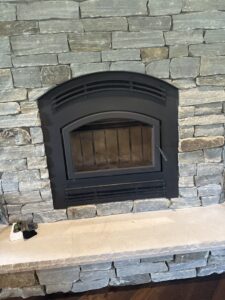 The clean interior of a fireplace firebox with a metal grate, maintained by Chimney Mechanix of Indiana in Lafayette, IN.