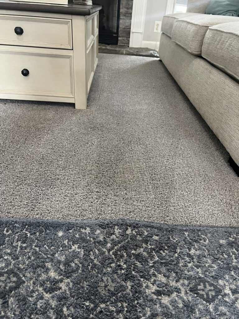 A clean grey carpet in a living room, indicating a completed job by Safe-Dry Carpet Cleaning of Clarksville, TN