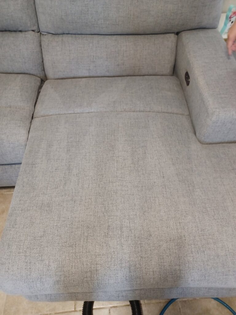 A clean section of a grey sectional sofa after professional upholstery cleaning by El Paso Carpet Care in El Paso, TX.