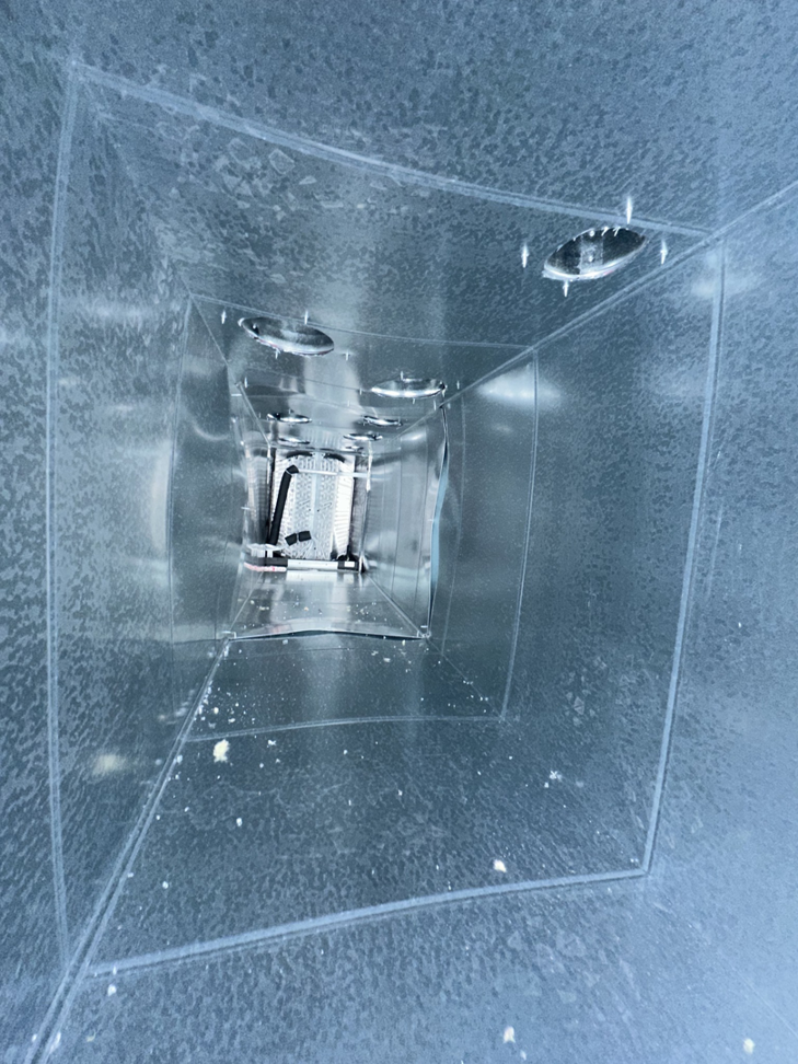 A clean interior view of a metal HVAC air duct system with circular vents by Arctic Desert Cooling & Heating in Concord, NC