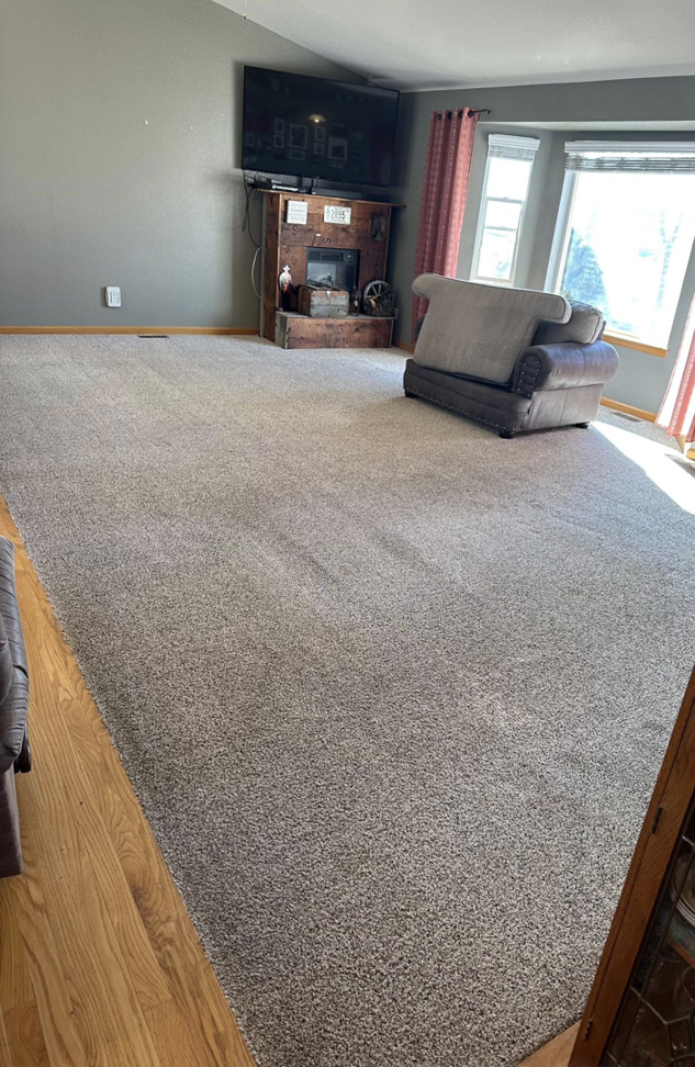 A spacious living room with a clean, light grey carpet after professional cleaning by North Colorado Kwik Dry Total Cleaning in Johnstown, CO.