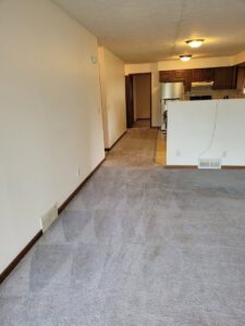 A clean living room carpet extending towards a kitchen, showcasing the work of Leo's Carpet Cleaning in Omaha, NE