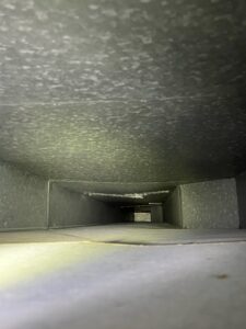 A bright view inside a clean metal air duct, showcasing the quality work of Vacman Air Duct Cleaning in South Bend, IN