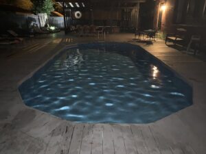 A beautifully clean swimming pool illuminated at night, reflecting the excellent maintenance by Pool King in Summerville, SC.