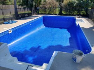 A clean pool with a pool vacuum hose submerged, indicating routine cleaning by Brian's Pool Service in Baton Rouge, LA.
