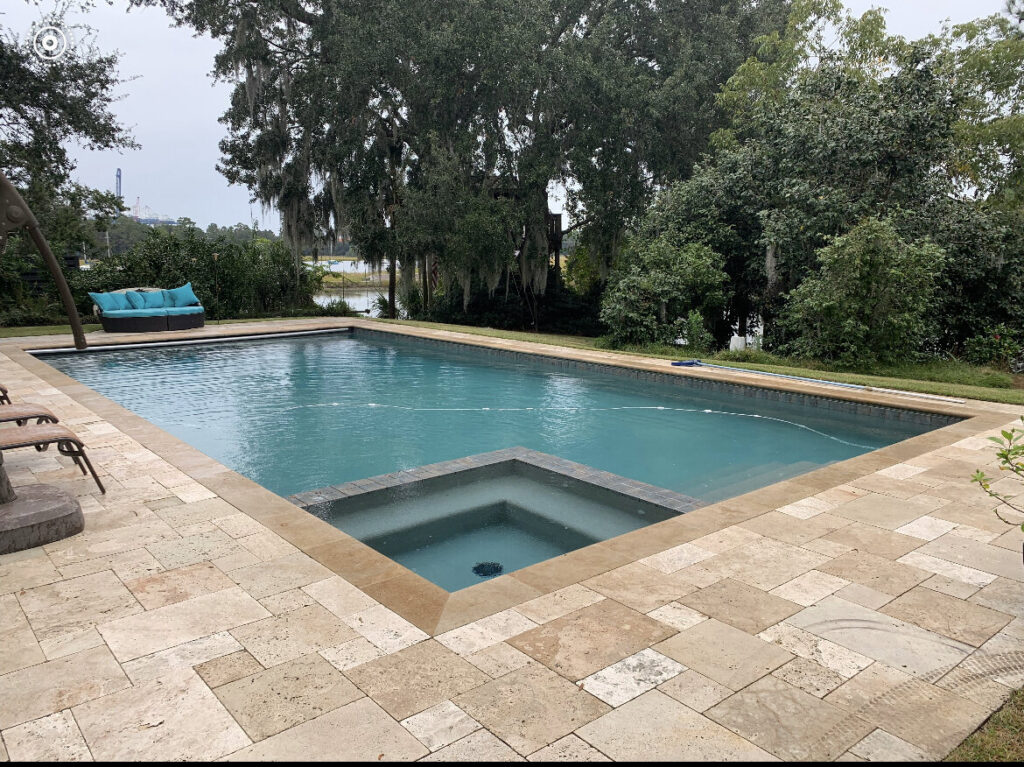A large, clean rectangular swimming pool with a built-in spa, maintained by Pool King in Southhold, NY.