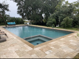 A large, clean rectangular swimming pool with a built-in spa, maintained by Pool King in Southhold, NY.