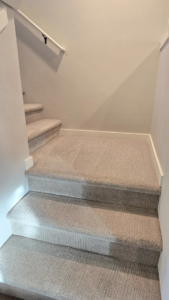 A clean, light-colored carpeted staircase in a residential home, maintained by Xtreme Carpet Cleaning Inc. in Sandpoint, ID.