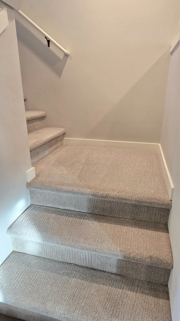 A clean, light-colored carpeted staircase in a residential home, maintained by Xtreme Carpet Cleaning Inc. in Sandpoint, ID.
