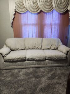 A clean upholstered sofa on a freshly cleaned carpet by Fiber Dry Carpet & Upholstery Cleaning in Dayton, OH.