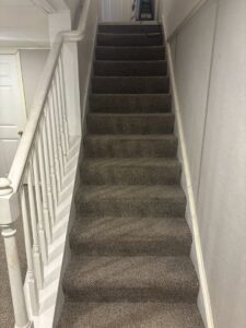 A freshly cleaned carpeted staircase with visible vacuum lines by Ready2go Professional Carpet & Upholstery Cleaning in Boston, MA