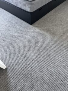 A freshly cleaned grey bedroom carpet with visible vacuum lines by Ready2go Professional Carpet & Upholstery Cleaning in Boston, MA