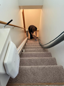 A technician from Sparkling clean meticulously cleaning carpeted stairs with specialized equipment in Salina, KS.