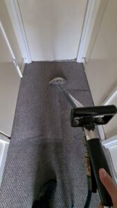 A professional cleaning tool being used to clean a hallway carpet by GreenLine Carpet Cleaning in Aurora, CO.