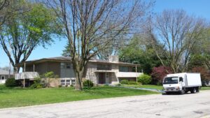 Blue cleaning hoses extending from a service vehicle to a house for a cleaning job by Jason Lostetter Carpet Cleaning in New Glarus, WI.