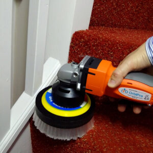 A professional cleaning a red carpeted staircase with a rotary brush tool for Johns Creek Carpet Cleaner in Johns Creek, GA.