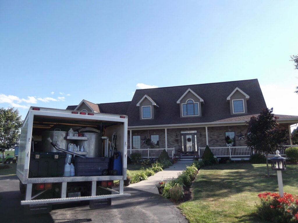 A Jason Lostetter Carpet Cleaning truck with equipment visible, parked at a client's home in New Glarus, WI.