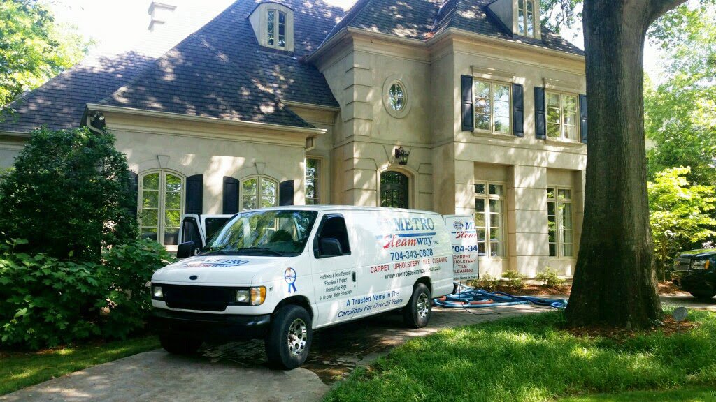Metro Steamway Inc. cleaning van parked at a residential job site with hoses running to the house in Charlotte, NC.