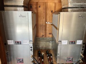 Two ClimateMaster geothermal heat pump units installed indoors by Trinity Climate Control, serving Goldsby, OK.