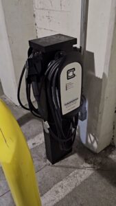 A ClipperCreek EV charging station installed in a parking garage, a service provided by 8Thirty Electric, Inc. in Johns Creek, GA.