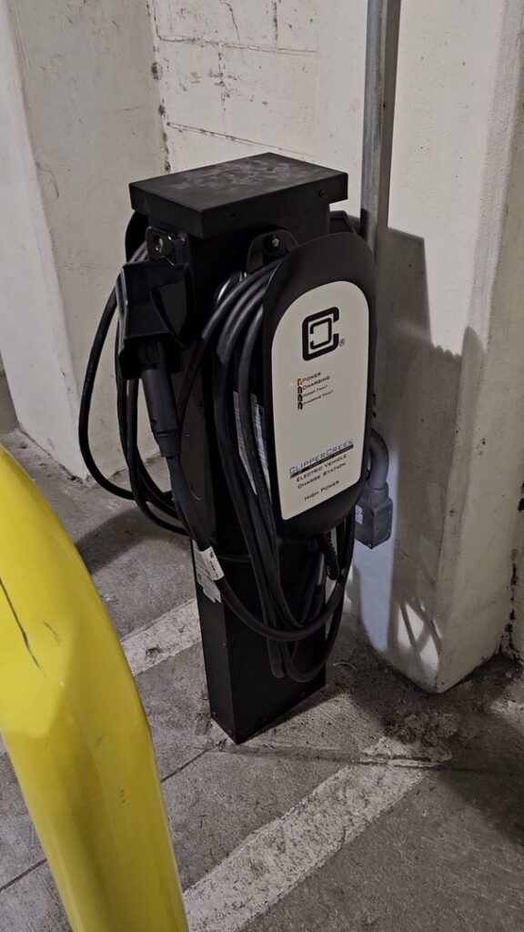 A ClipperCreek EV charging station installed in a parking garage, a service provided by 8Thirty Electric, Inc. in Johns Creek, GA.