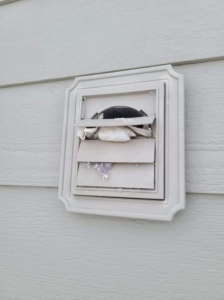 A clogged exterior dryer vent cover showing lint buildup, indicating a need for cleaning by Aero Brush Duct Cleaning in Billings, MT.
