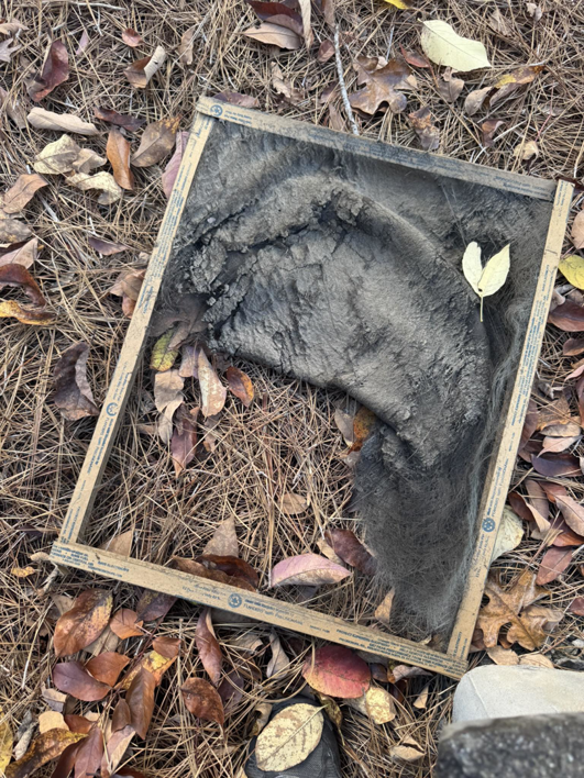 A severely clogged HVAC air filter lying on the ground, indicating the need for maintenance from Northstar Solutions in Reidsville, NC.