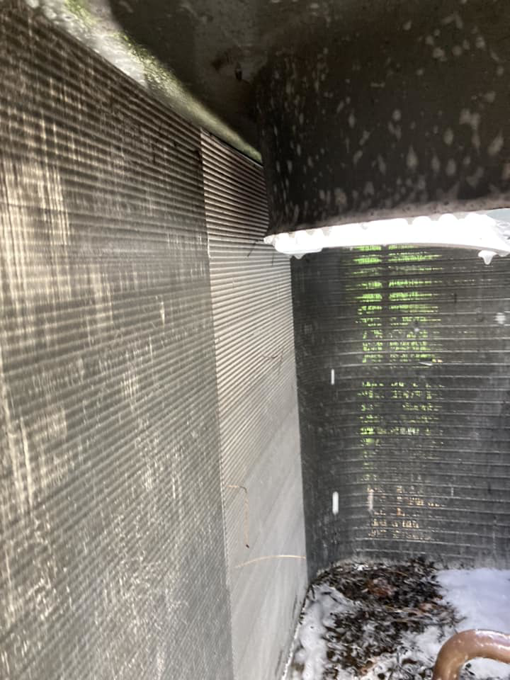 A close-up view of AC condenser fins being cleaned during maintenance by Your Angel Heating And Cooling LLC in Cary, NC.
