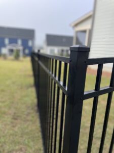 A close-up view of a black aluminum fence post and panels, highlighting detail by RDU Fence in Holly Springs, NC.