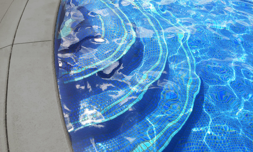 A close-up of blue mosaic tiles on pool steps, showcasing work by Midwest Custom Pools, LLC in Lawrence, KS.
