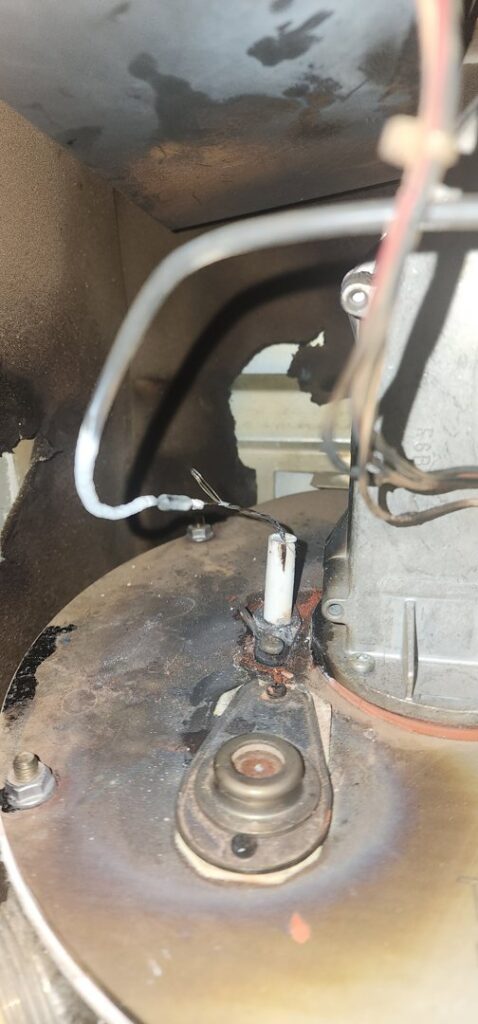 A close-up view of a burner or ignition component inside a heating unit serviced by HeatSource Mechanical in Wasilla, AK.