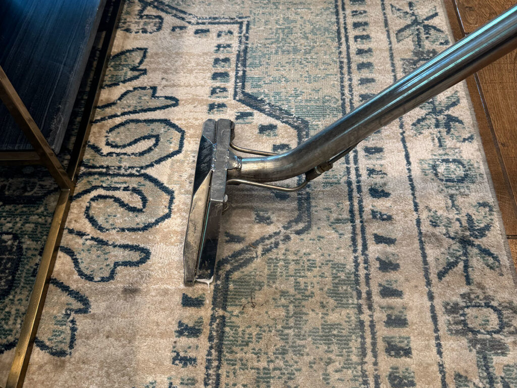 A close-up of a carpet cleaning tool in action on an area rug by Get Steamed Carpet Cleaning, Inc. in North Charleston, SC.