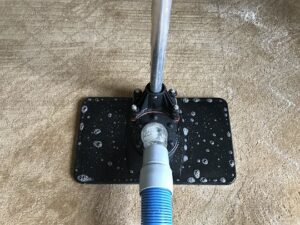 A close-up view of a carpet cleaning tool with cleaning solution bubbles on a carpet by North County Carpet Cleaning in Vancouver, WA