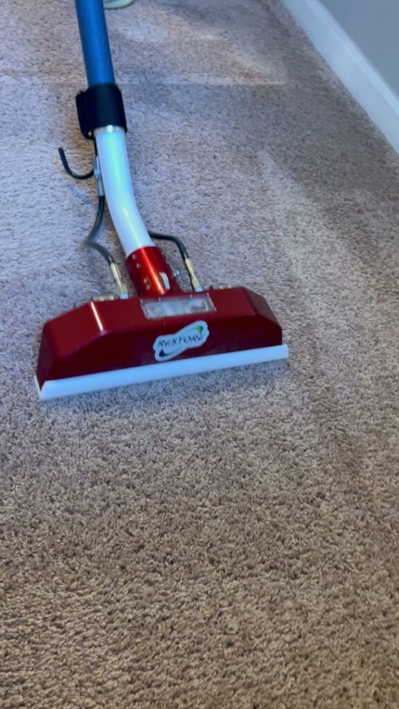Close-up of a carpet cleaning wand removing dirt from a light-colored carpet by Restore Carpet Care and Tile in Tallahassee, FL