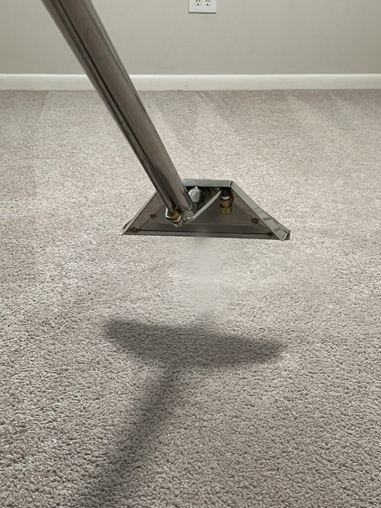 A close-up view of a professional carpet cleaning wand steaming and cleaning a carpet by J&P United in Rochester, NY.