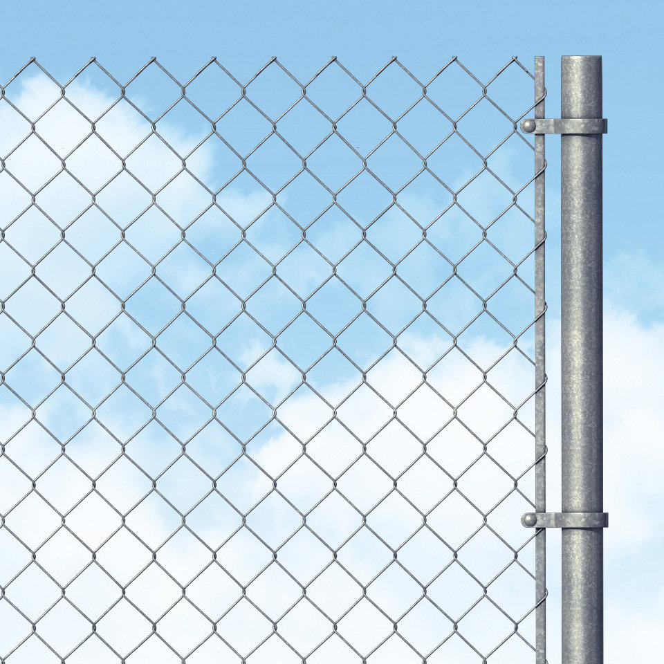 A close-up view of a chain-link fence post and mesh against a blue sky, installed by National Construction Rentals in Las Vegas, NV.