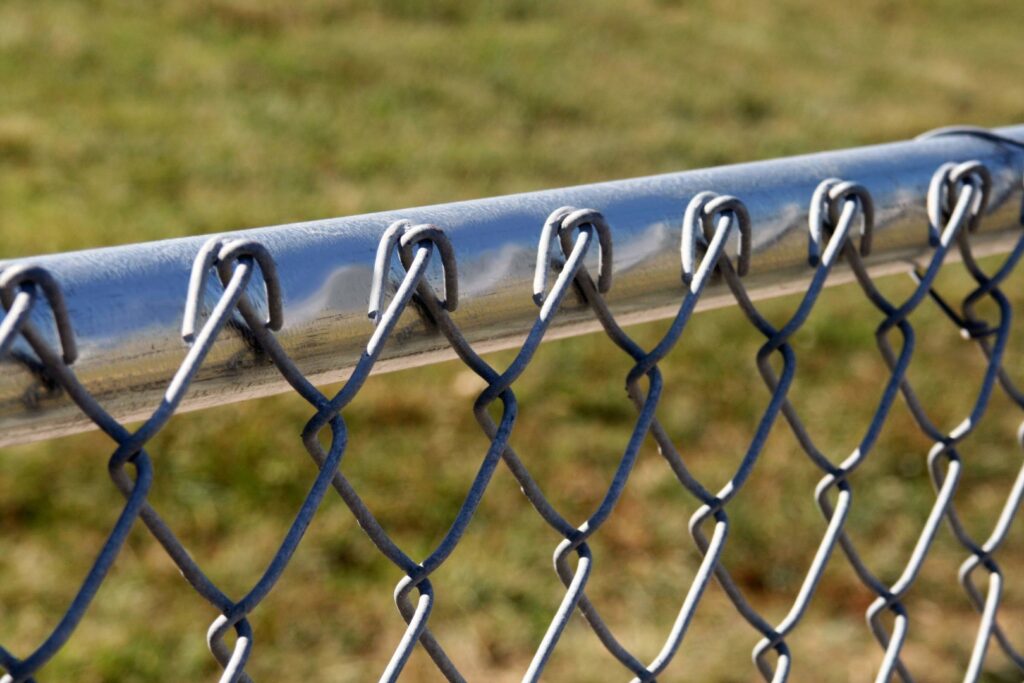 A close-up view of the top rail of a chain-link fence installed by American Fence Company - Omaha in Omaha, NE.