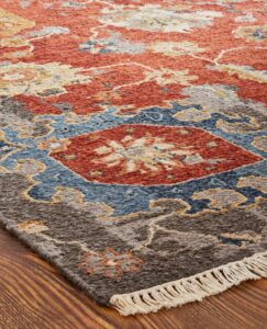 A close-up view of a colorful patterned area rug with fringe, available from Odino Designs, llc in Portland, OR.