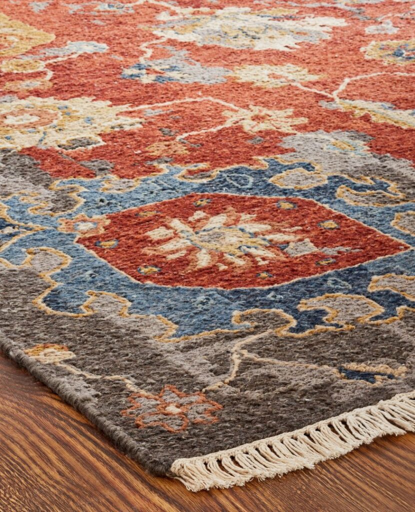 A close-up view of a colorful patterned area rug with fringe, available from Odino Designs, llc in Portland, OR.