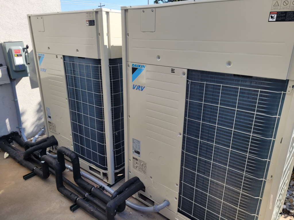 A close-up view of Daikin VRV outdoor HVAC units with piping installed by SleepRite Heating & Cooling in Conway, AR.
